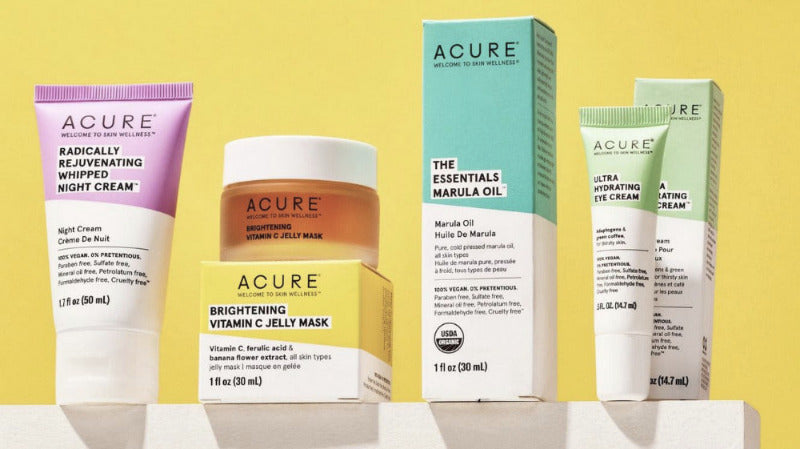 Acure skincare products including cream, mask, and box on a yellow background
