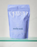 Purple package of 'epzen soothe soak' on a clear surface with a light gray background