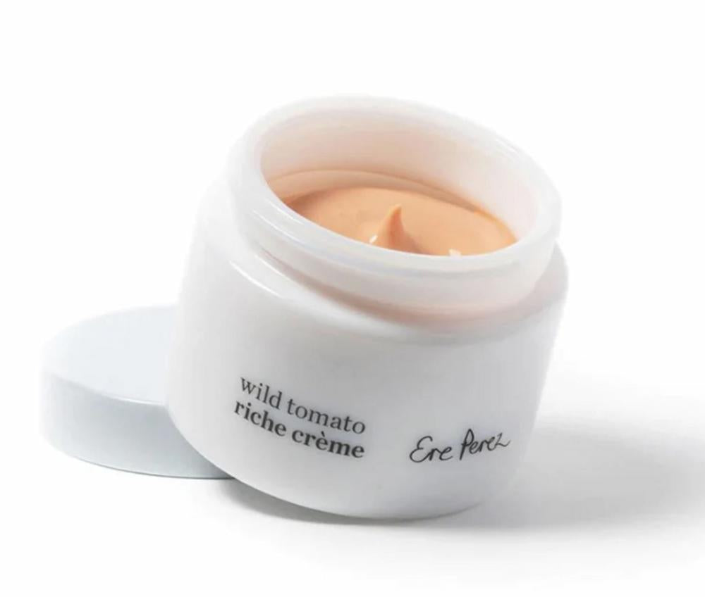 Jar of 'wild tomato riche crème' cream with visible brand name on a white background