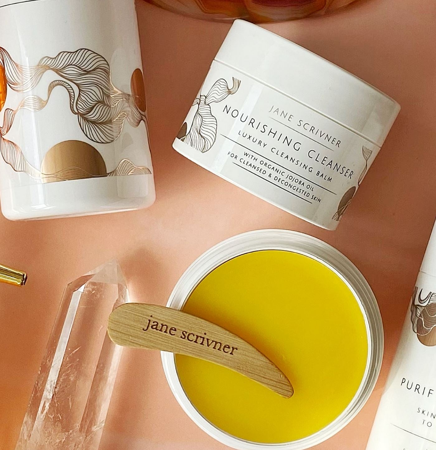 Skincare products with 'Jane Scrivener' branding on a peach-colored background