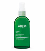 Green Weleda bottle with white cap on a white background